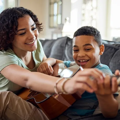 Pediatric ulcerative colitis patient playing guitar with a parent