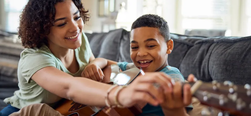 Pediatric ulcerative colitis patient playing guitar with a parent